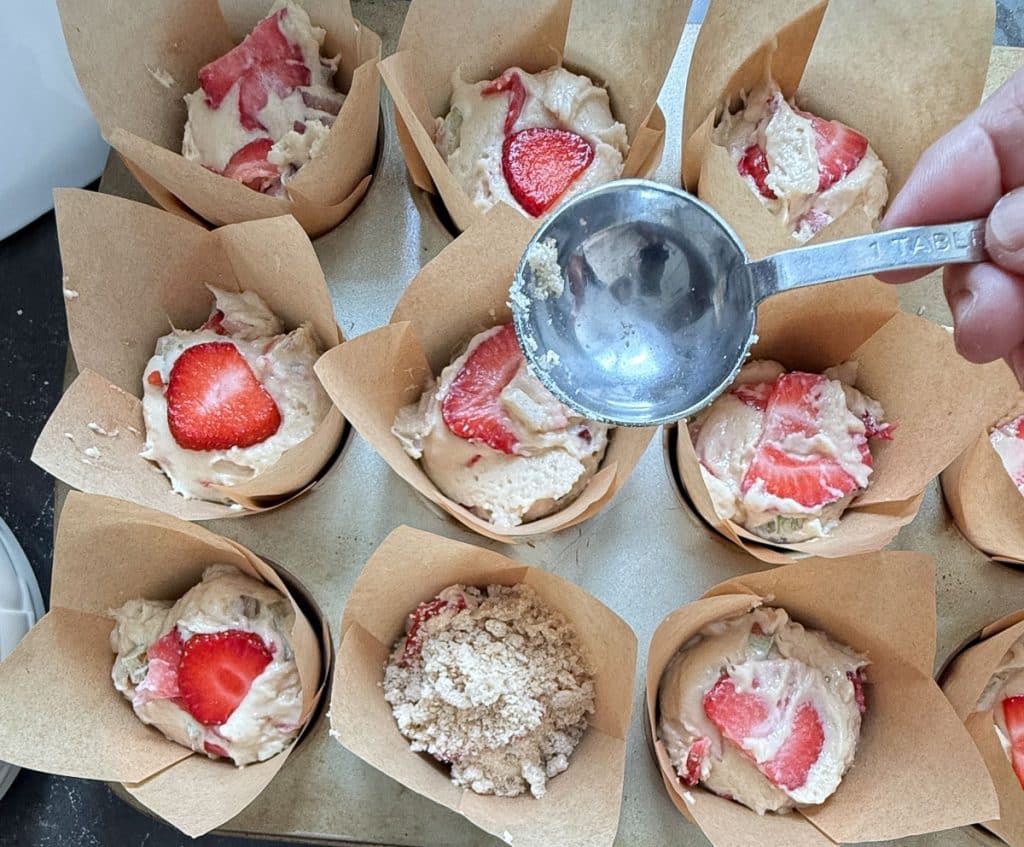 adding crumble top to strawberry rhubarb muffin batter