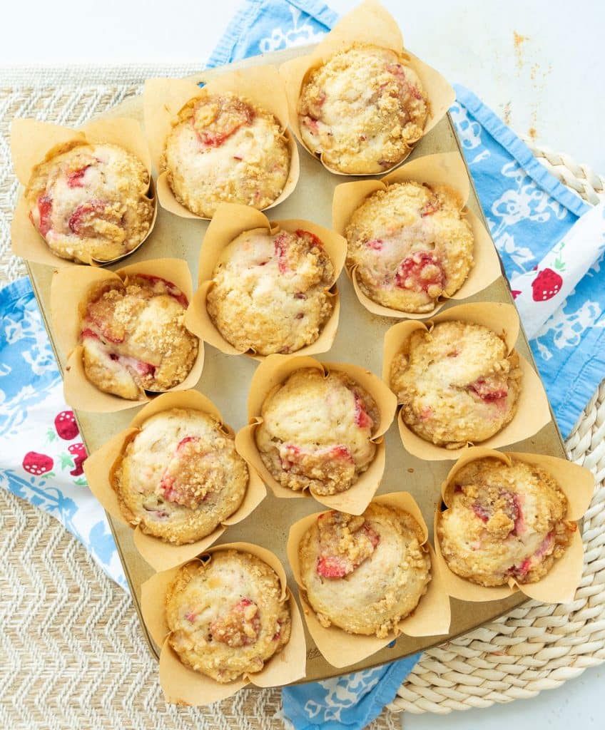 DSCN7685 muffin pan full of baked strawberry rhubarb muffins on a blue and white cloth on a white table