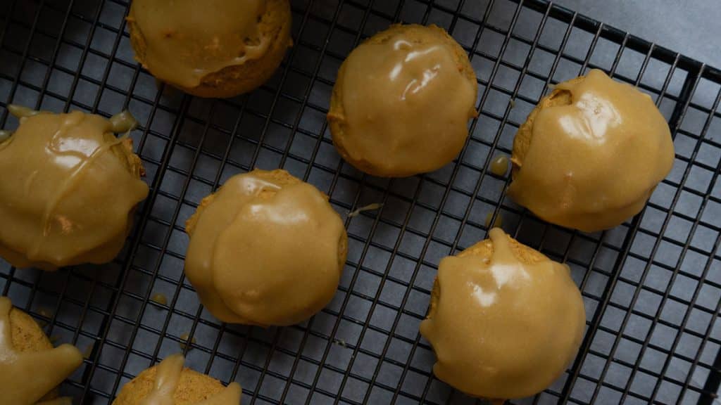 frosted pumpkin cookies on a cooling rack