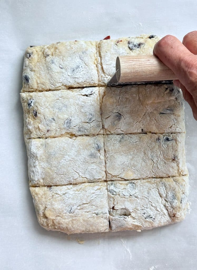 cutting scones into 8 rectangle shapes on a parchment lined baking sheet