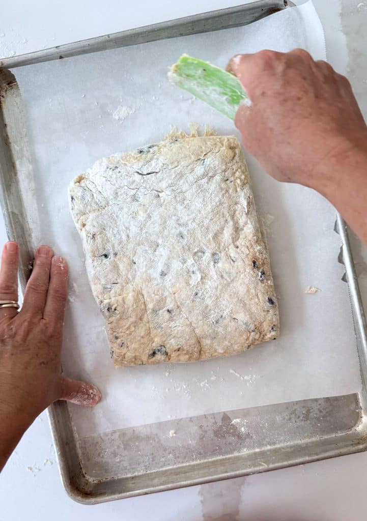 shaping scones into a rectangle on a parchment lined baking sheet