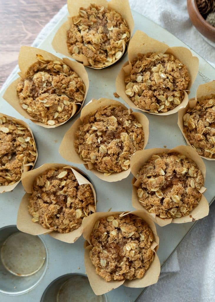 muffin tin with baked whole wheat pumpkin oatmeal muffins in the pan on a kitchen counter