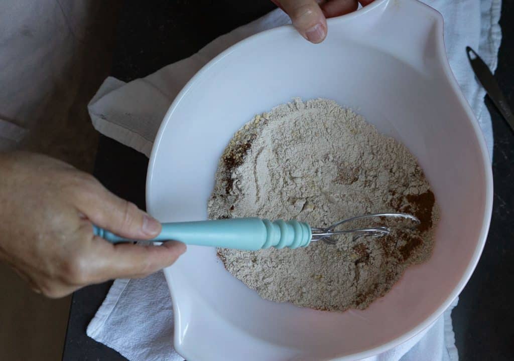 IMG_0473 whole flour in a white bowl with spices, and salt being mixed together with a bread whisk
