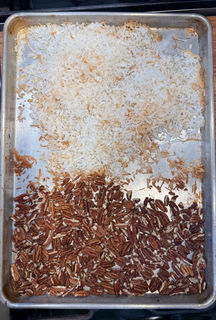coconut and pecans on a baking sheet