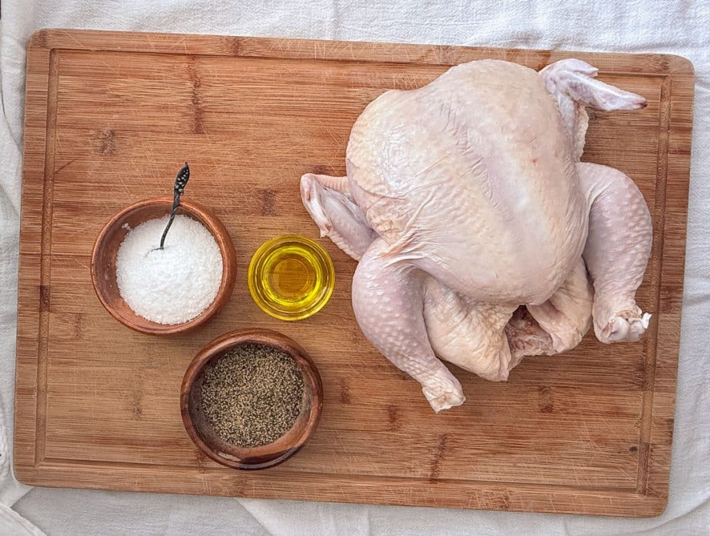 ingredients for roast chicken on a wood cutting board