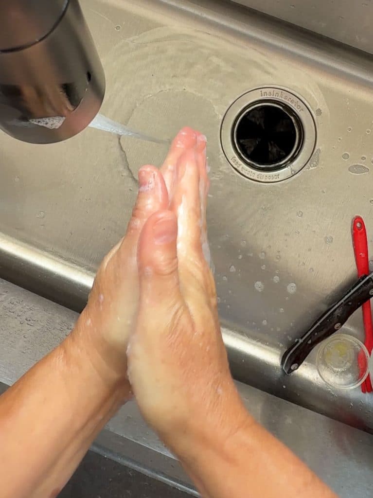 washing hands in a stainless steal sink