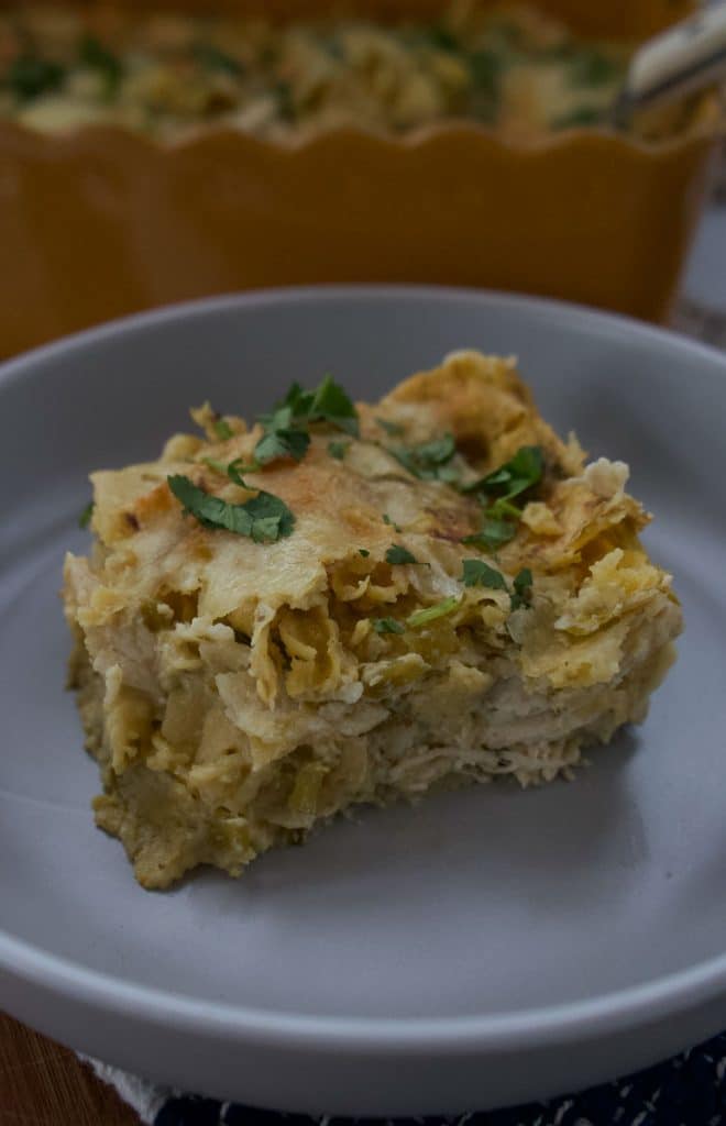 a square of chicken enchiladas verde sitting on a gray dish