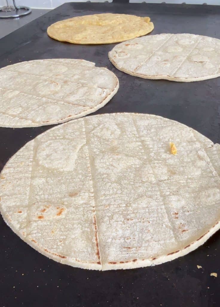cooking corn tortillas on a flat top griddle
