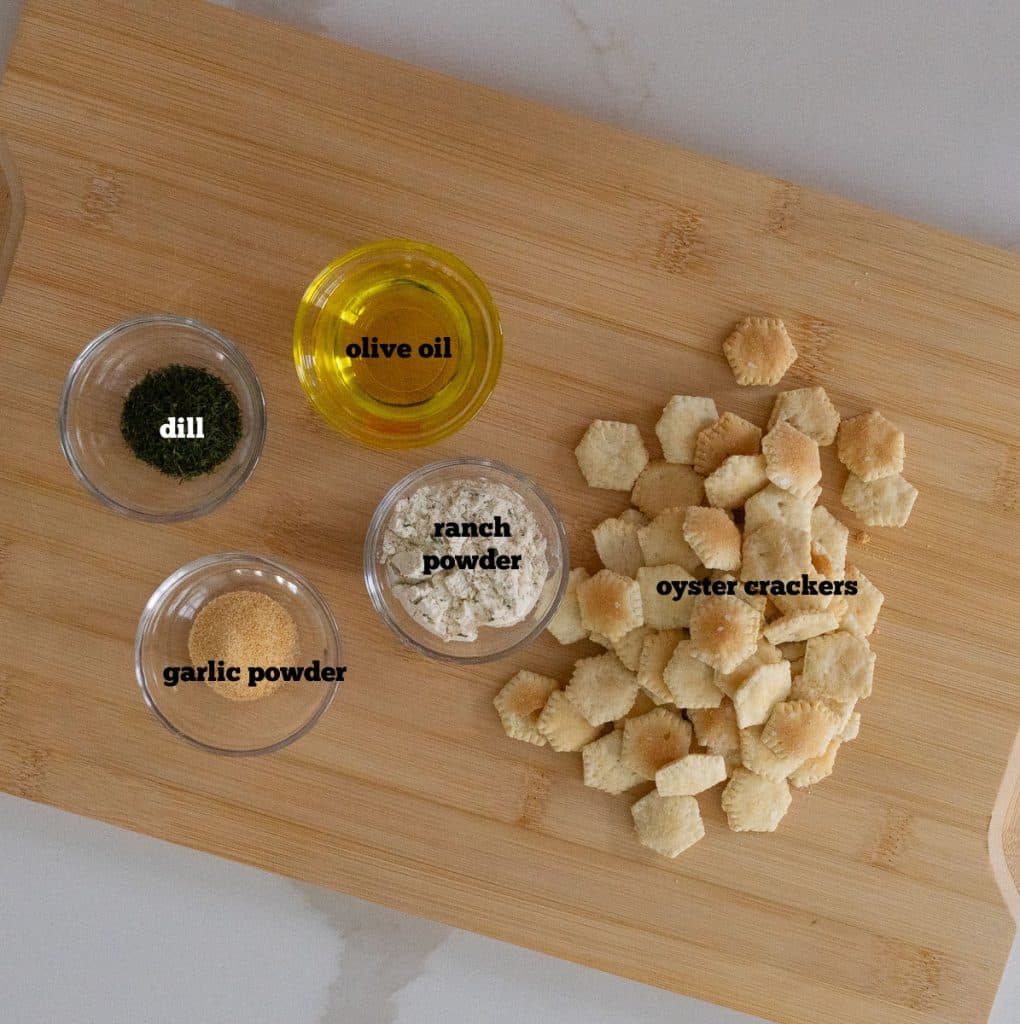 ingredients for munchie crackers on a wood cutting board