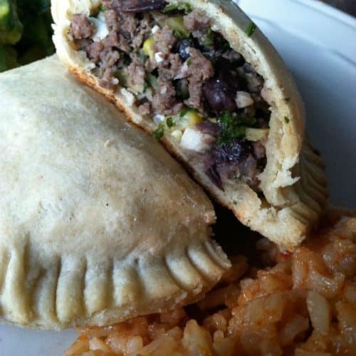 corn and black bean empanada on plate with rice