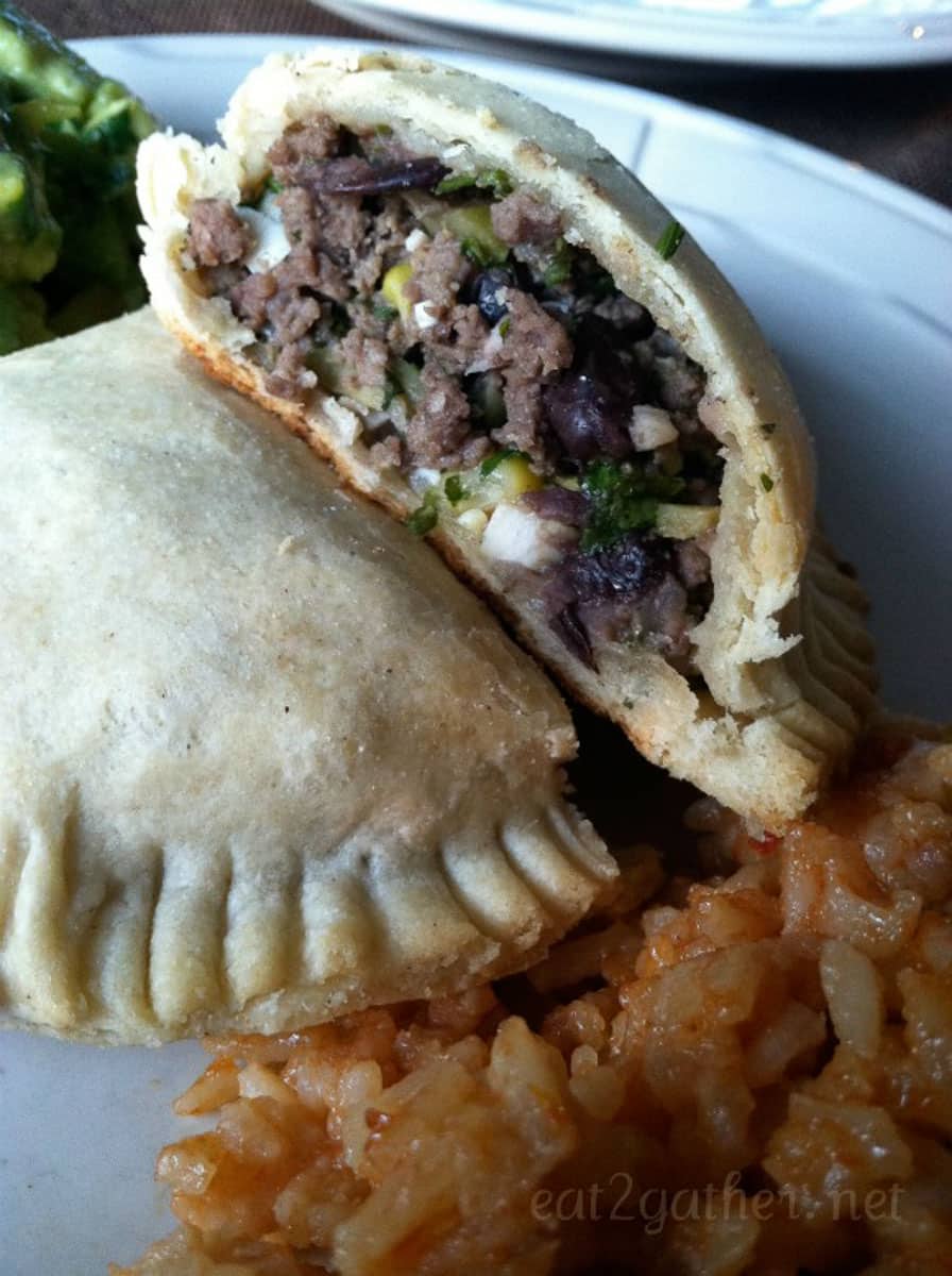corn and black bean empanada on plate with rice