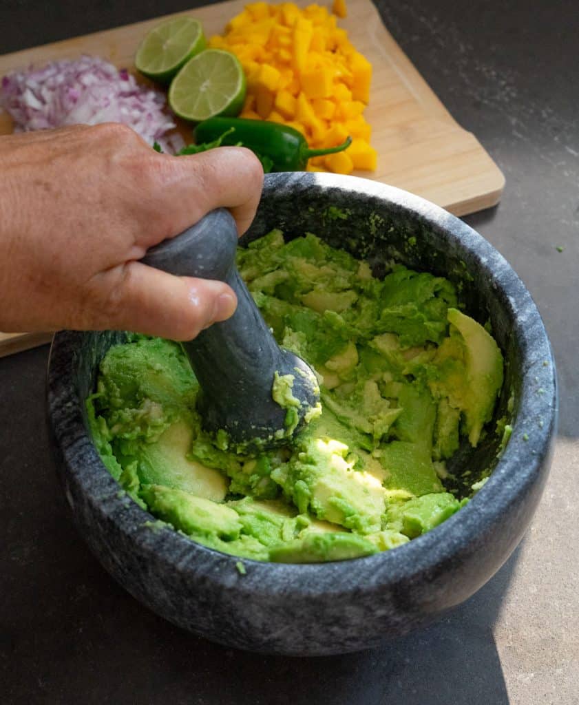 IMG_6644 mashing avocado in stone bowl with a pestle