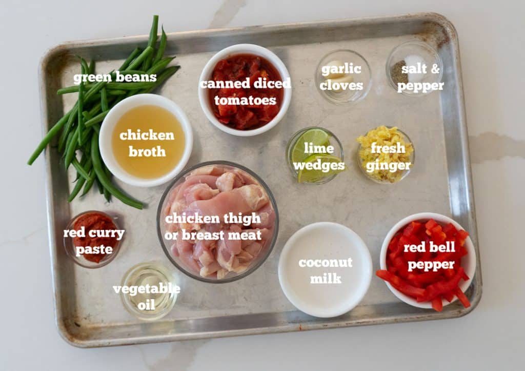 ingredients for tha curry soup on a baking sheet on a white countertop
