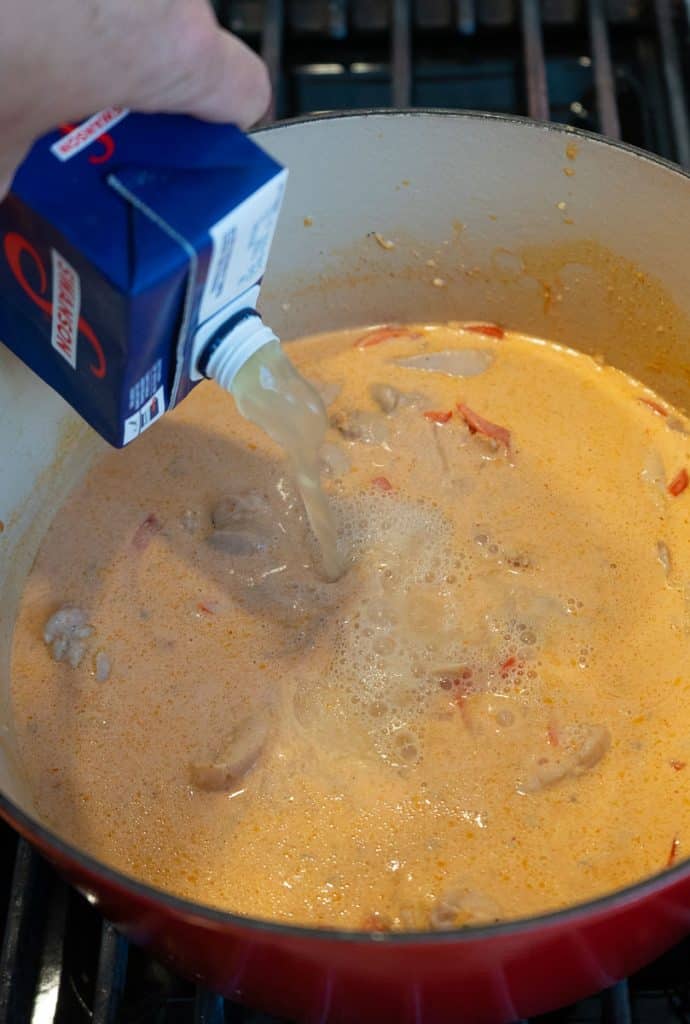 adding chicken stock to the pan