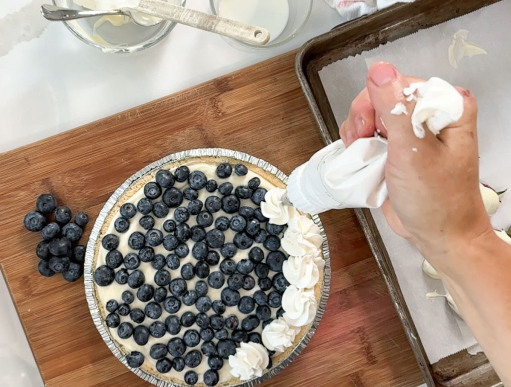 piping whipping cream around the edge of pie
