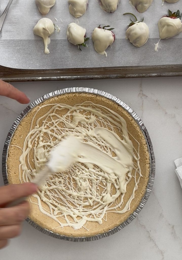 spreading white chocolate inside the pie shell