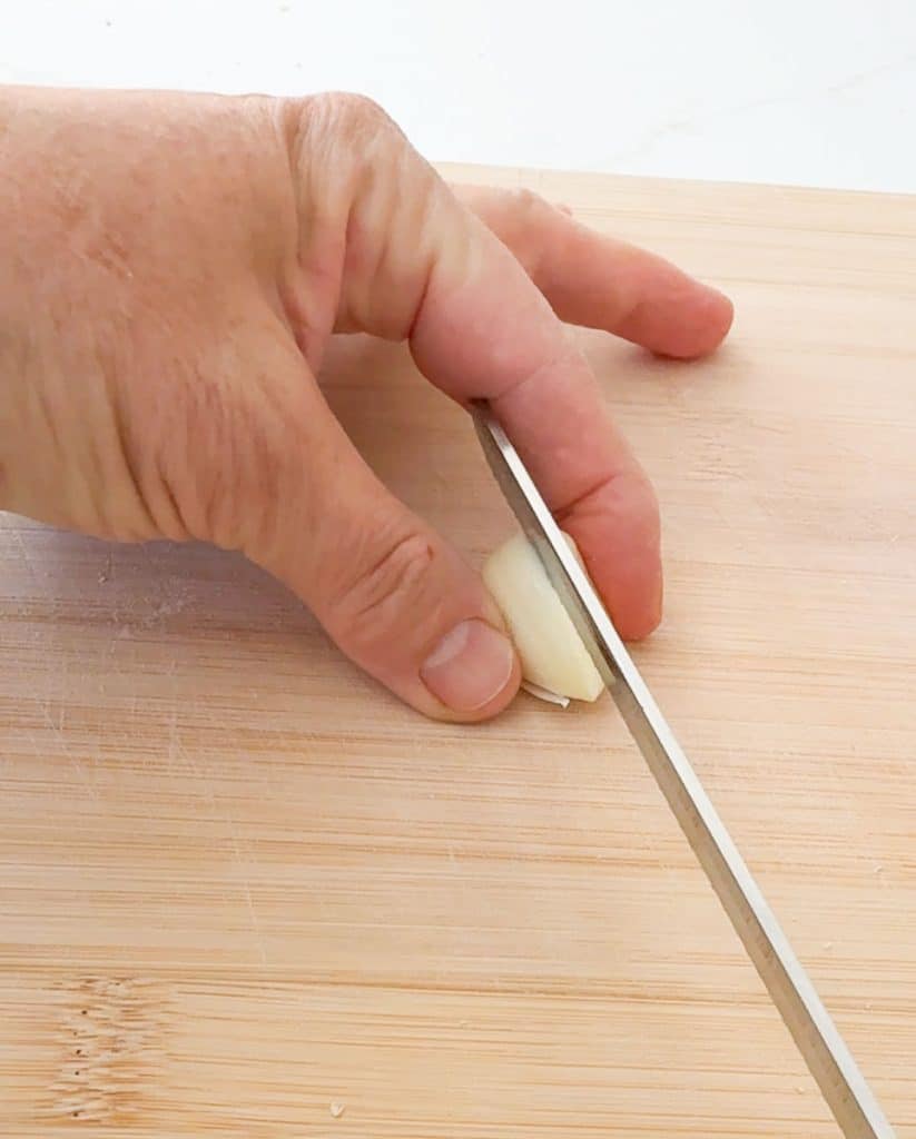 slicing a garlic clove in half