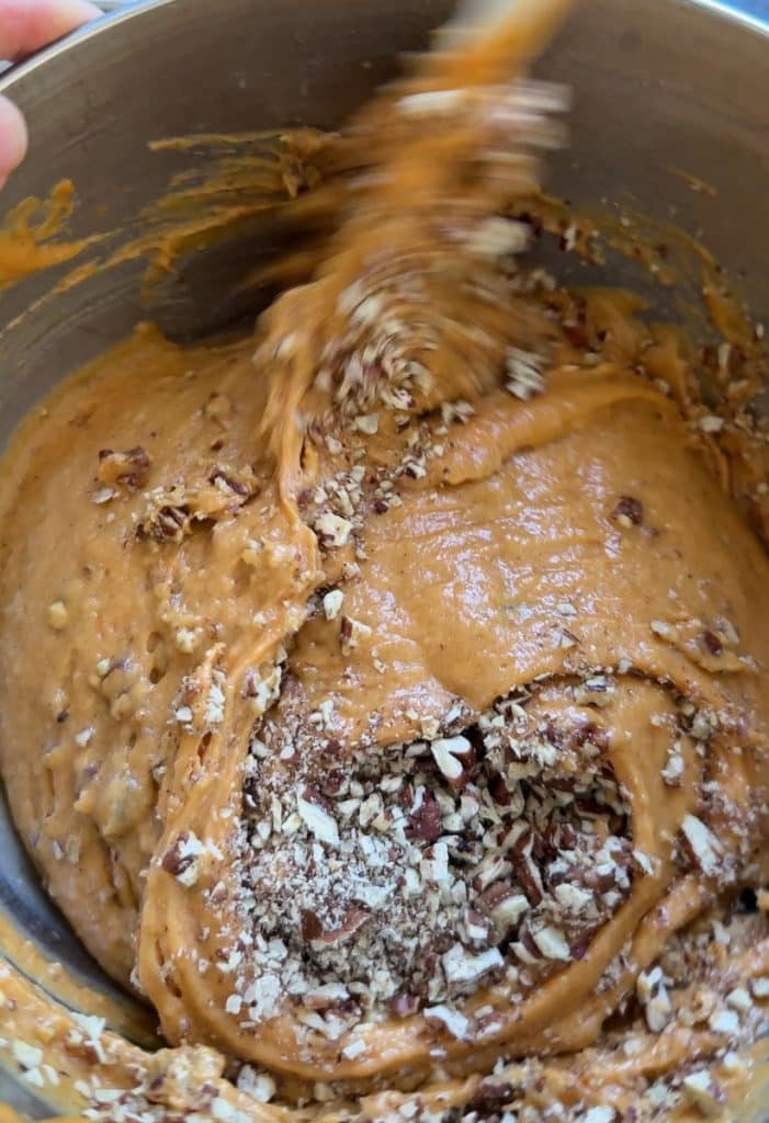 folding pecans into pumpkin bundt cake batter