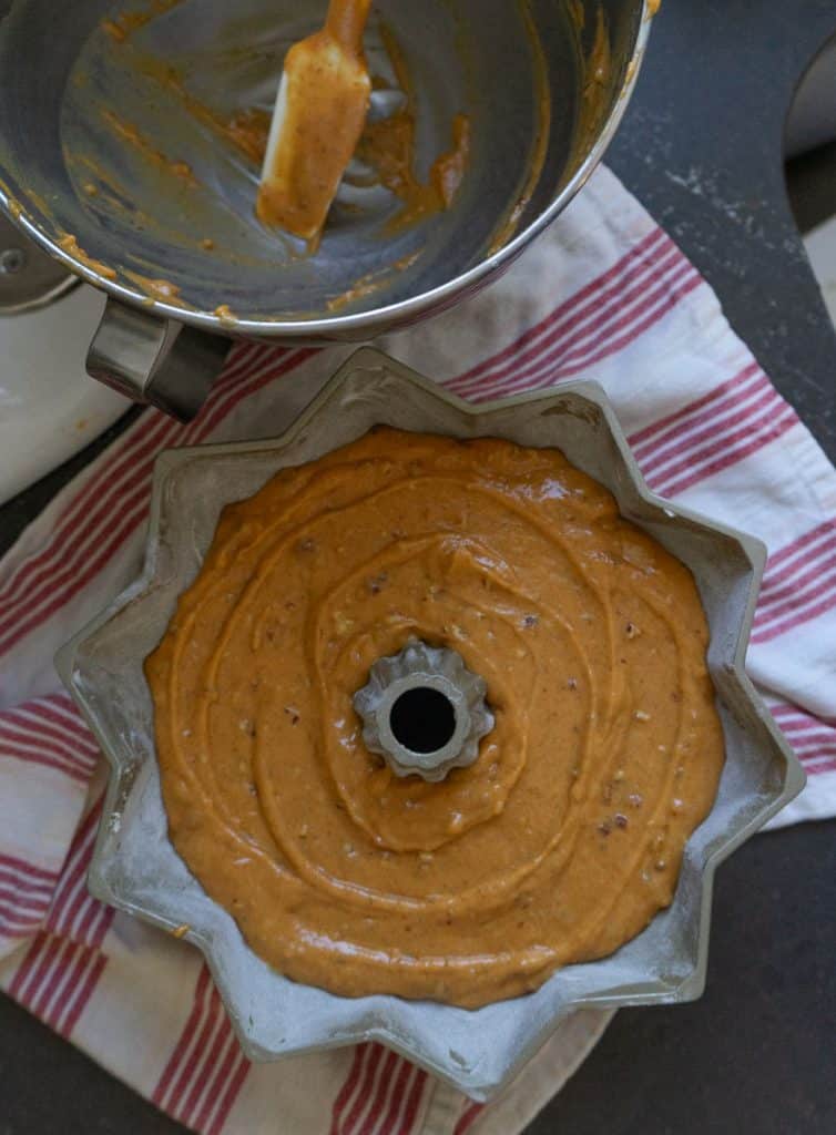 Bundt cake pan with pumpkin cake  batter next to stand mixer