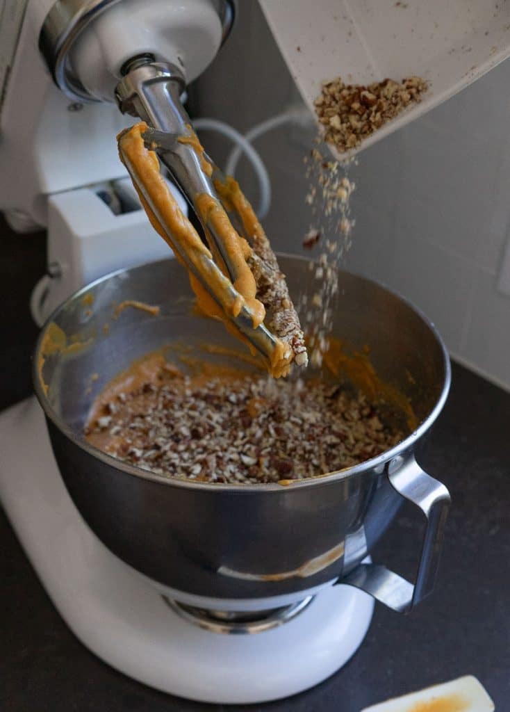 adding in chopped pecans to pumpkin bundt cake 