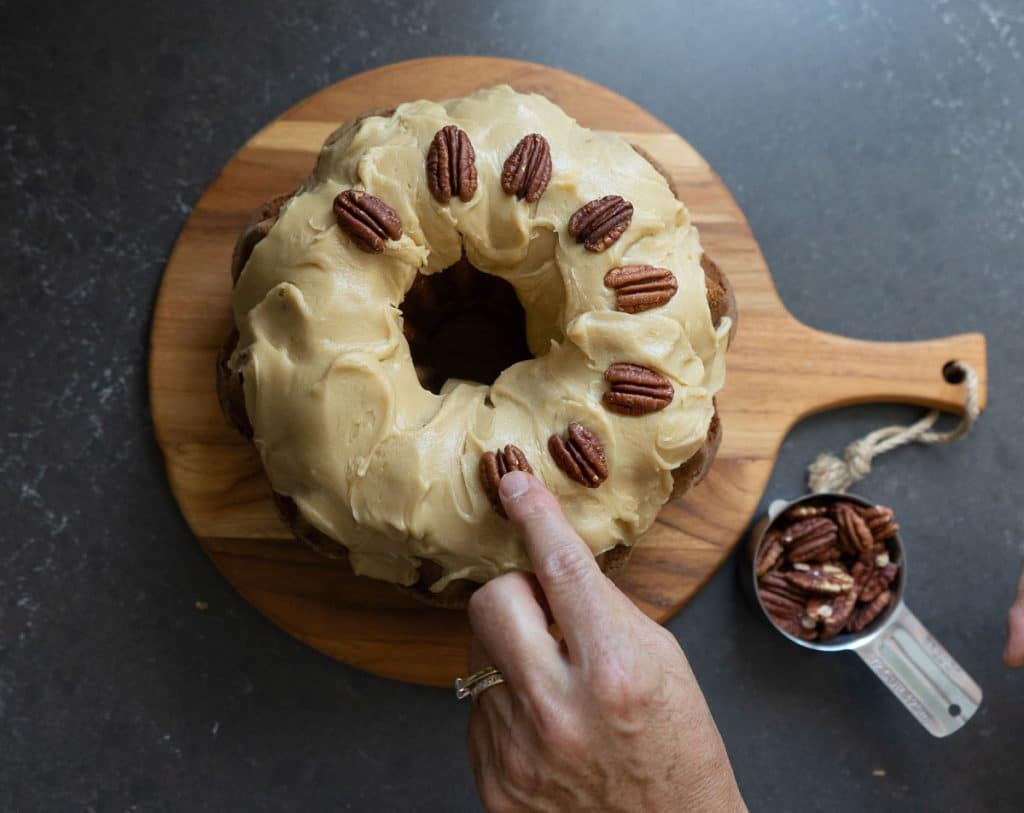 Add toasted pecans to the top of the caramel pumpkin bundt cake
