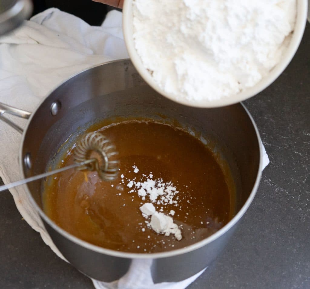adding powdered sugar to saucepan