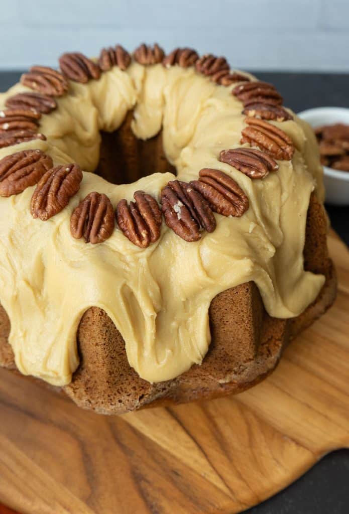 caramel pumpkin bundt cake setting on a wood cake plate 