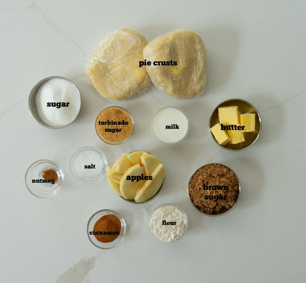 ingredients for apple pie on a white countertop