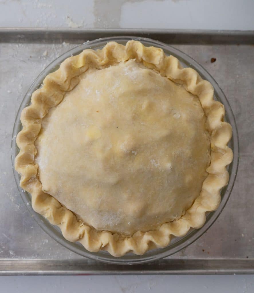 whole apple pie on a baking sheet before baking