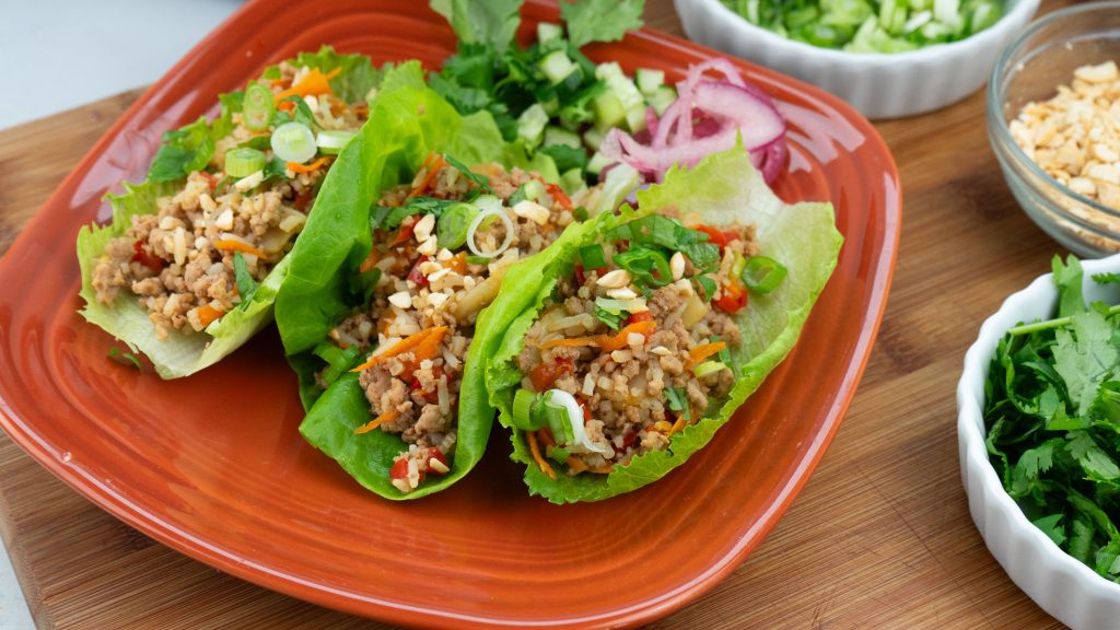 chicken lettuce wraps on a brown plate