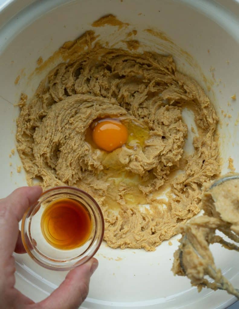 making brown sugar spice cookies: brown sugar and butter mixture with an egg, and vanilla being added to the bowl