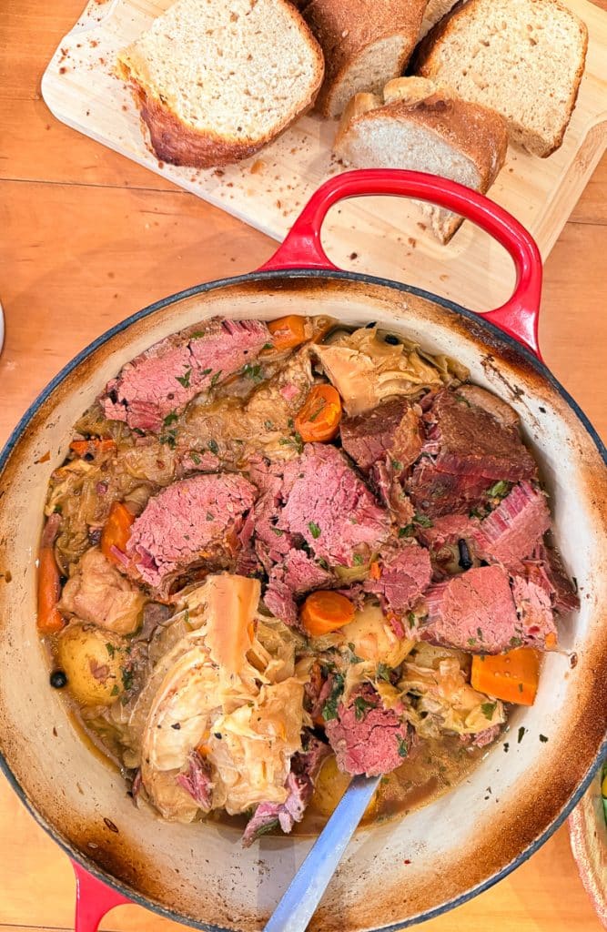 phot of corned beef on kitchen table with sliced irish soda bread on the side