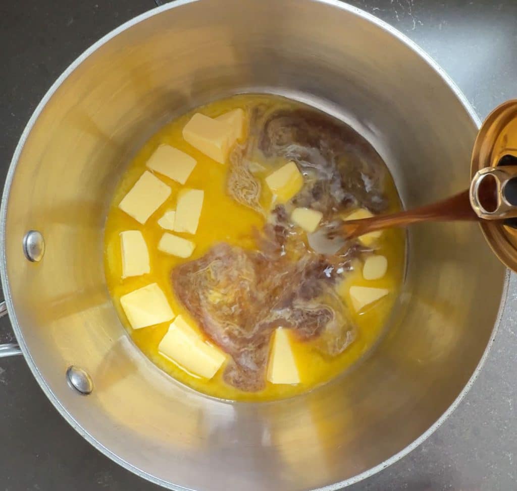 melting butter in a sauce pan guinness beer being poured into pan from the right side