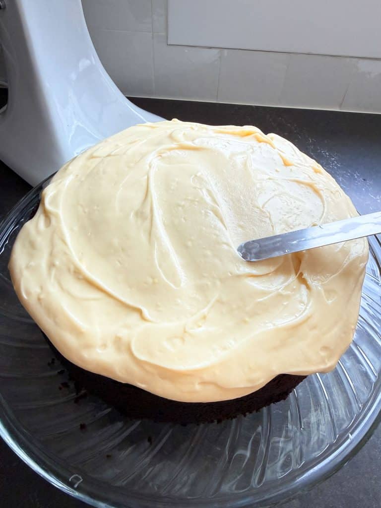 spreading frosting on top of cake with a off set spatula 