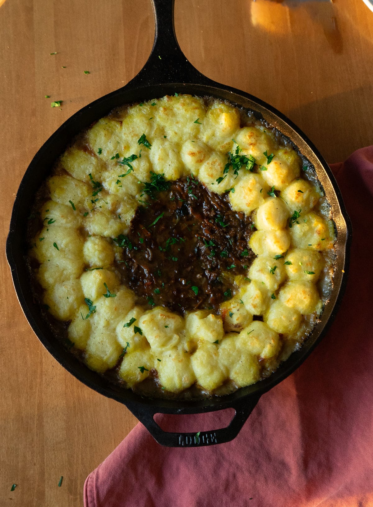 shepherds pie in a cast iron skillet on a wood table top