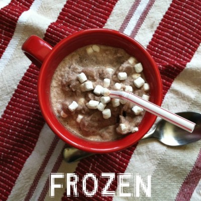 red mug with frozen hot chocolate with tiny marshmallows floating on the top on a red and white striped cloth