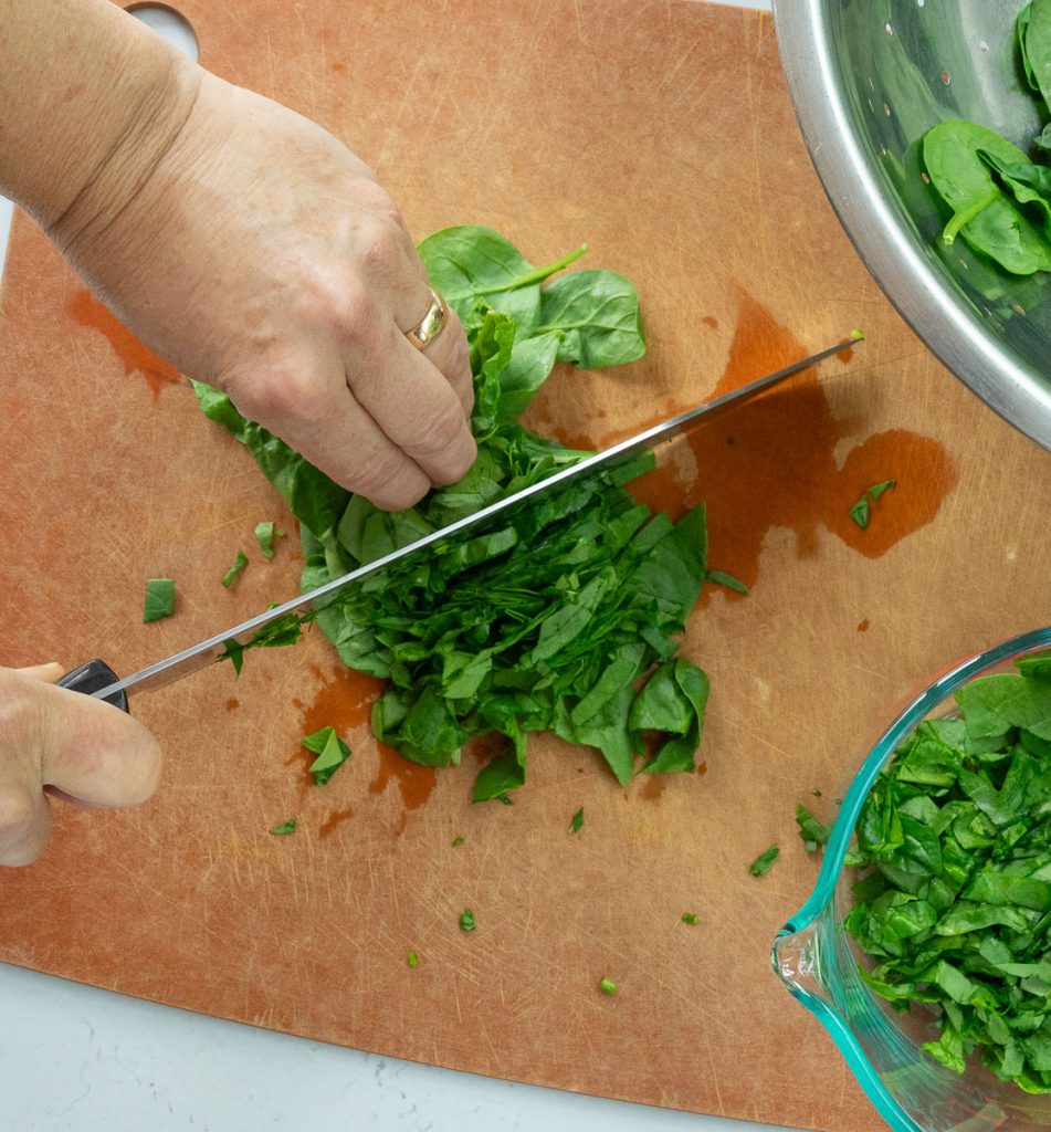 Chopping spinach on a cutting board
