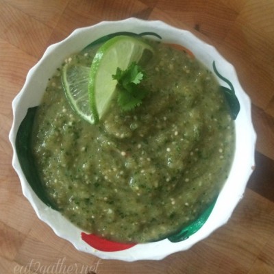 bowl of green salsa verde garnished with a lime