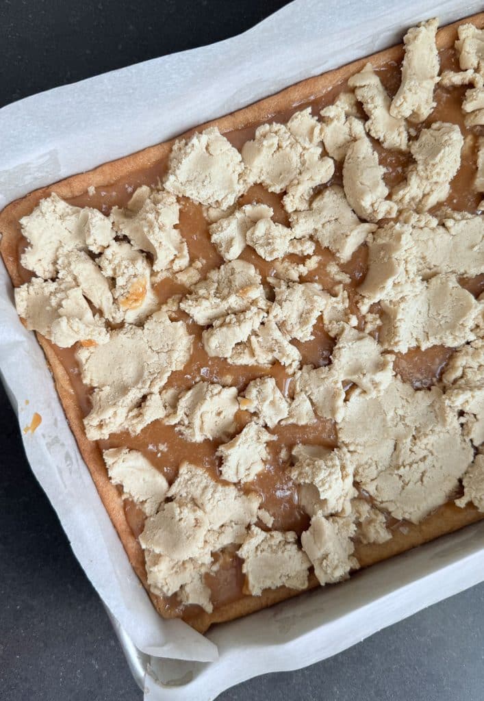 second layer of shortbread crumbled over top of caramel layer in a baking pan