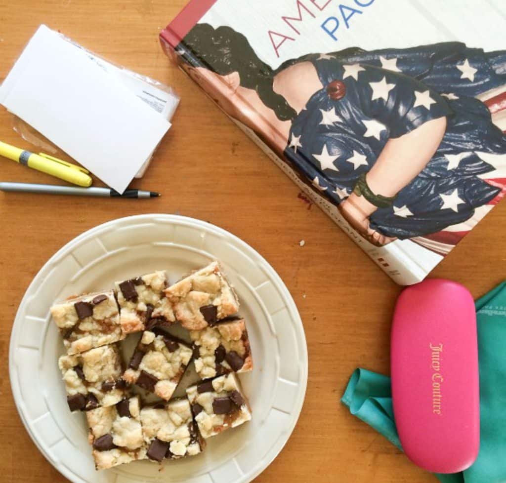 photo of a table with homework and a plate of salted caramel bars on a plate