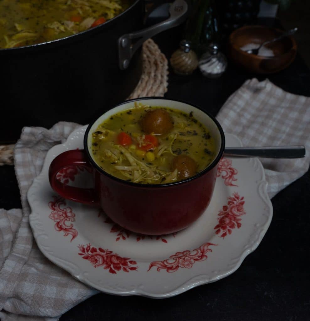 bowl of chicken and red skin potatoe soup with the pot of soup in background to theleft