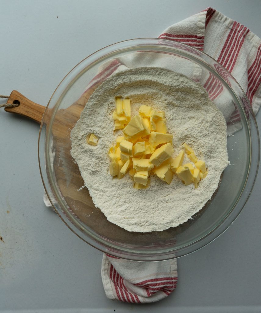 dry ingredients in glass blow with butter cubes 