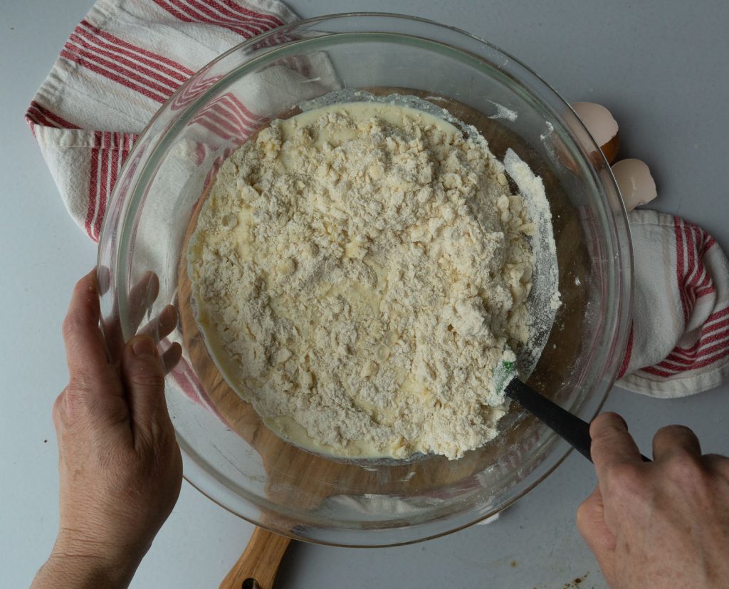 combining wet and dry ingredients in a glass bowl
