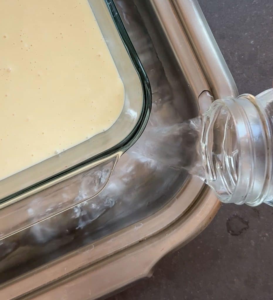 pouring water around cheesecake pan for a water baking bath