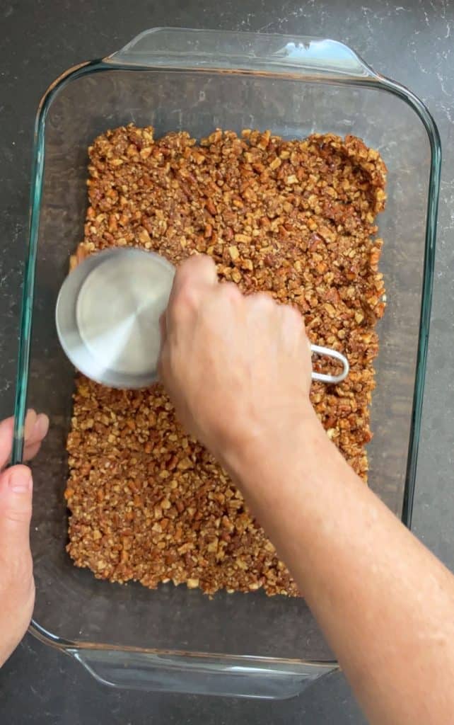 pressing pretzel crust down into the bottom of a 9x13 inch baking dish