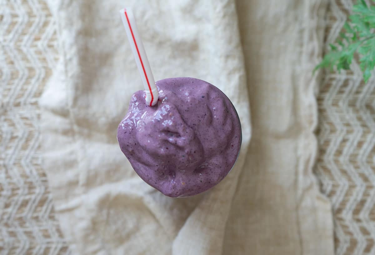 picture of a purple smoothie in a glass with a straw in the glass