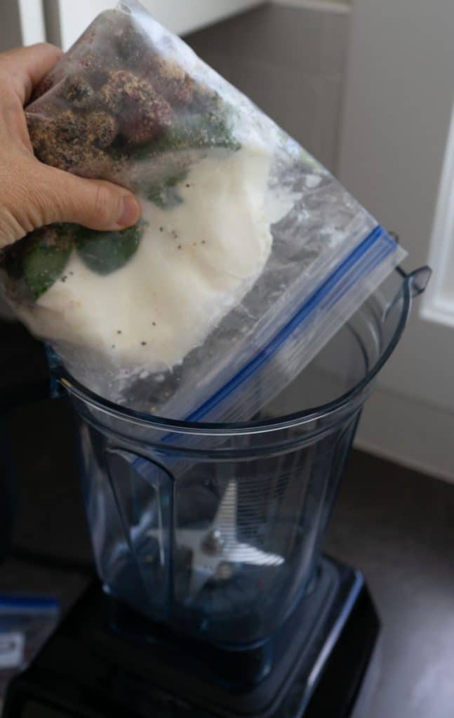 dumping freezer smoothie ingredients out of plastic bag into blender