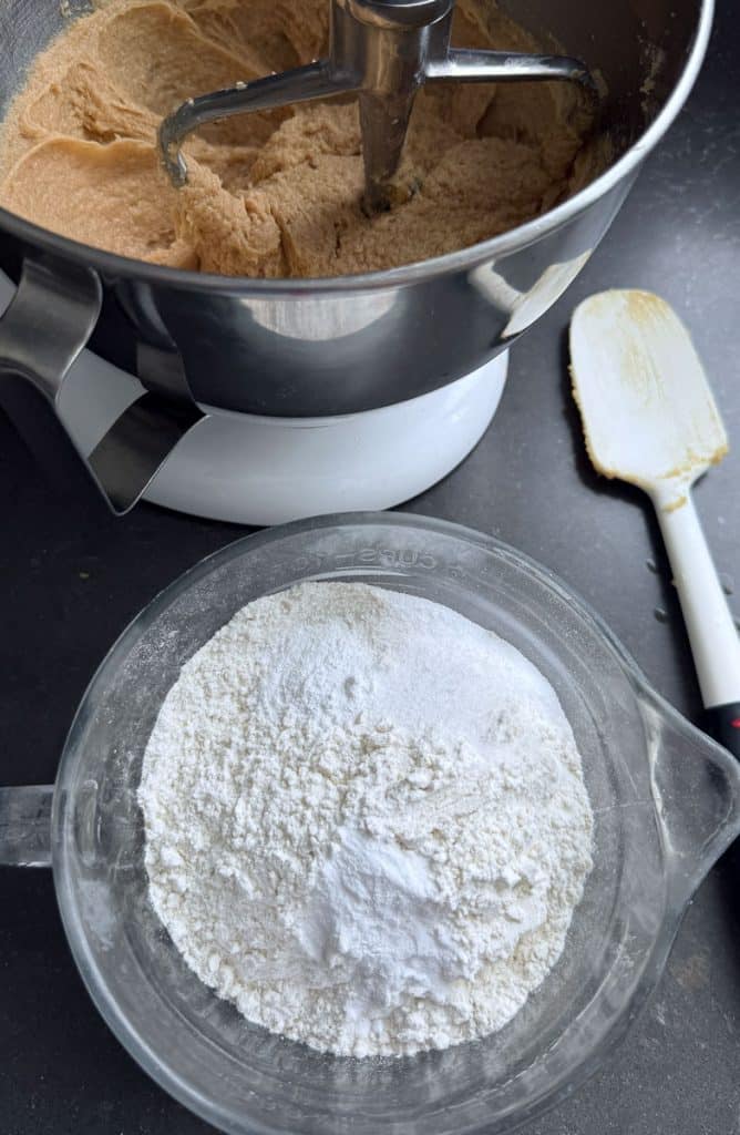flour measured into a glass bowl next to butter sugar mixture