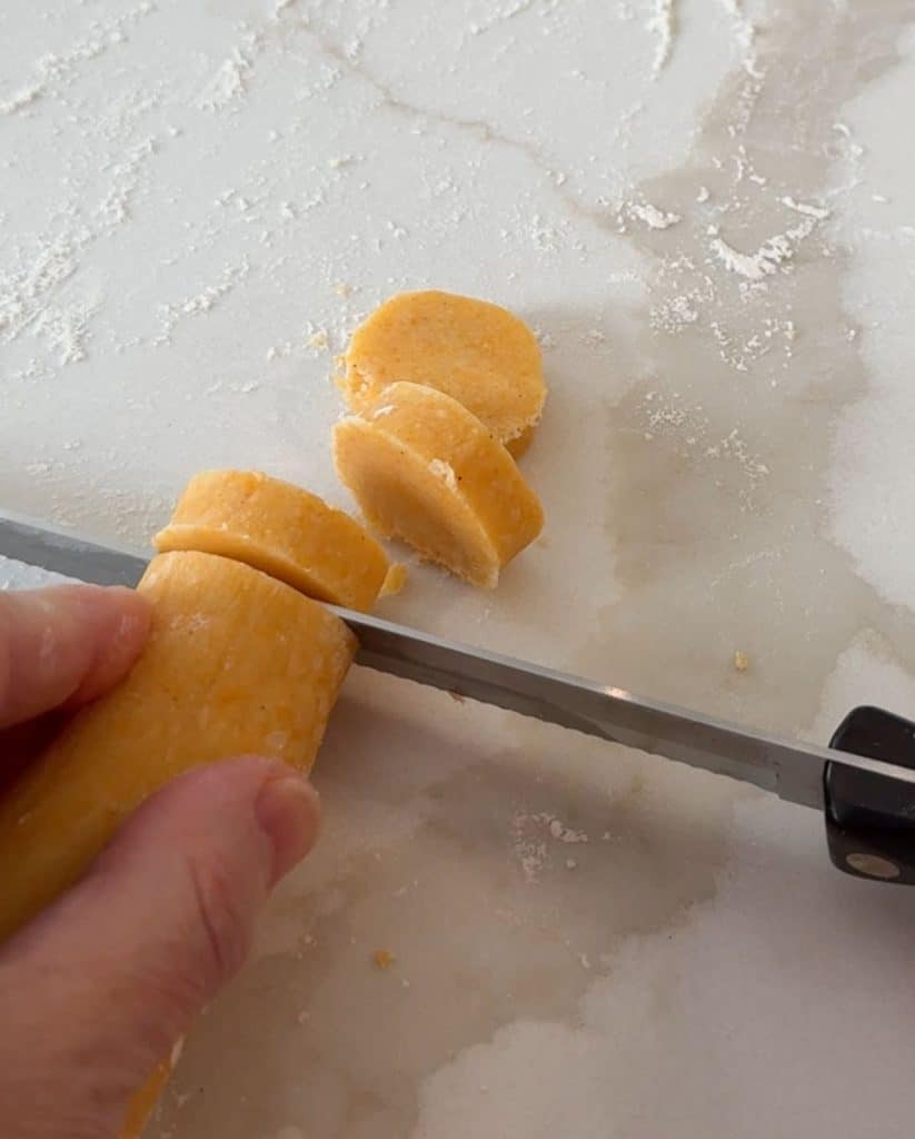 slicing cheese cracker dough into discs