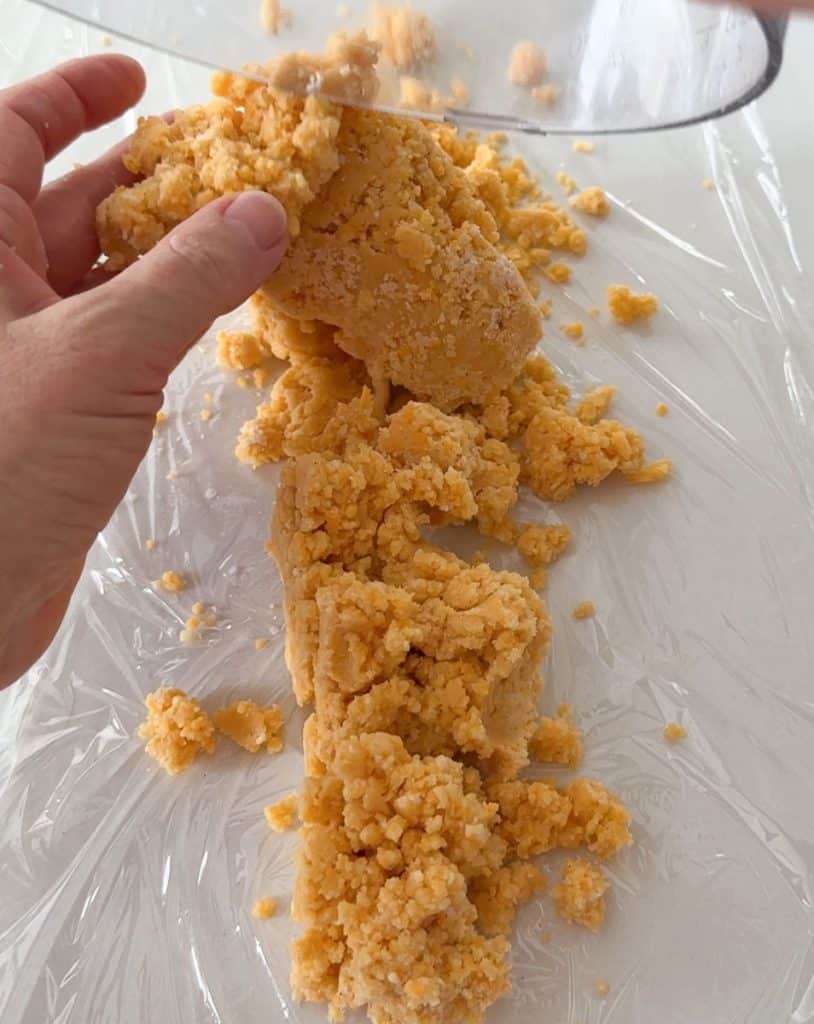 dumping cheese cracker dough out onto plastic wrap